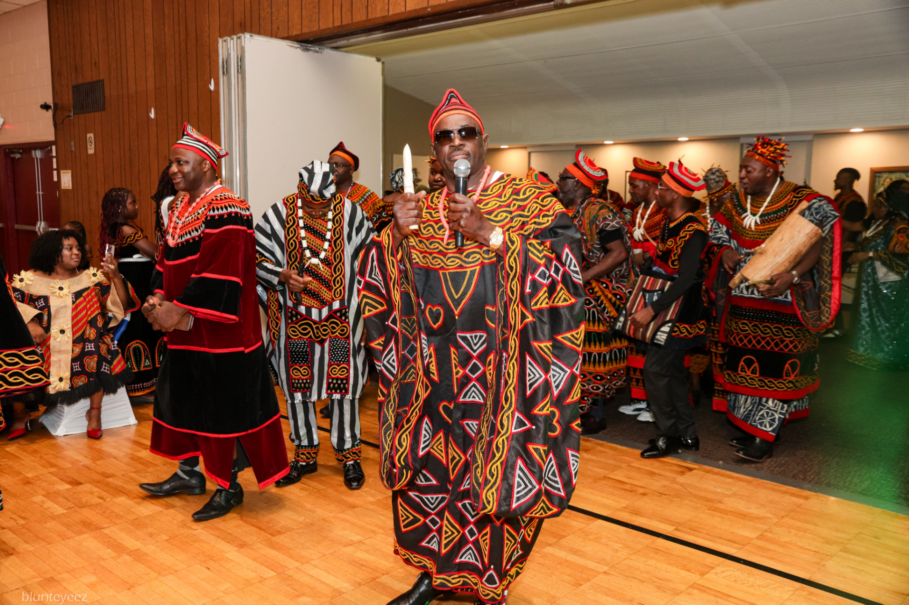 Elder leading a procession in traditional Nkwen regalia